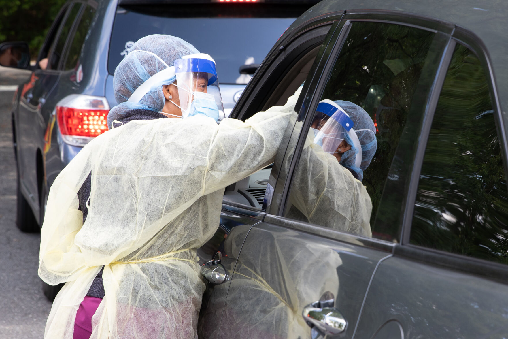 Photo_News_CovidTesting_NurseReachingIntoCar.jpg